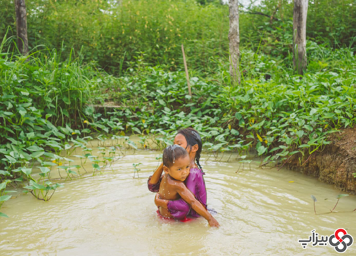 دو کودک در برکه‌ ای در کامبوج حمام می‌ کنند